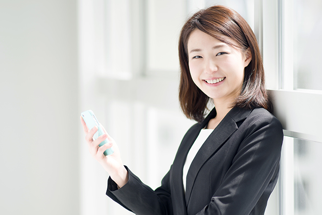 スマホを持ってほほ笑む女性
